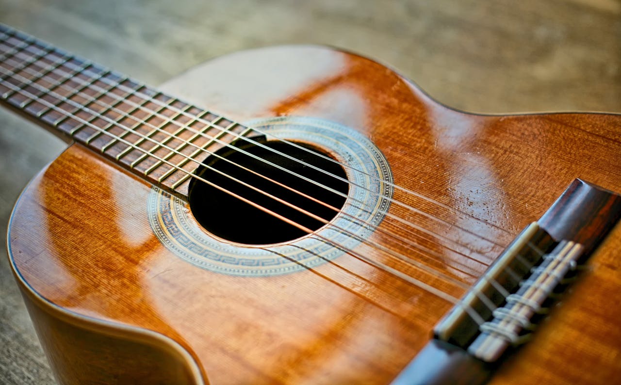 Detailed view of a classical acoustic guitar focusing on strings and soundhole.